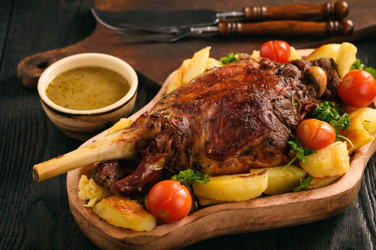 A beautiful looking smoke roasted lamb leg surrounded by roasted veg