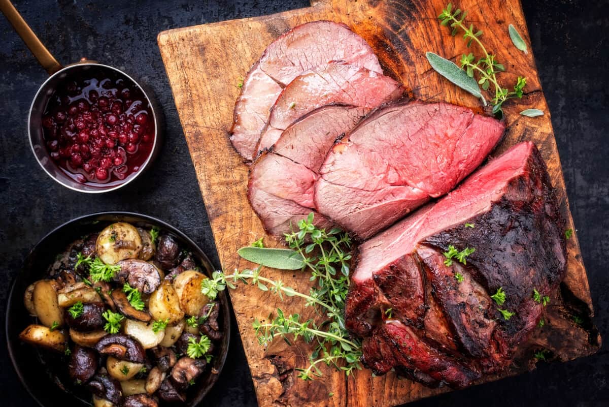 A smoked and sliced venison haunch showing pinkness inside