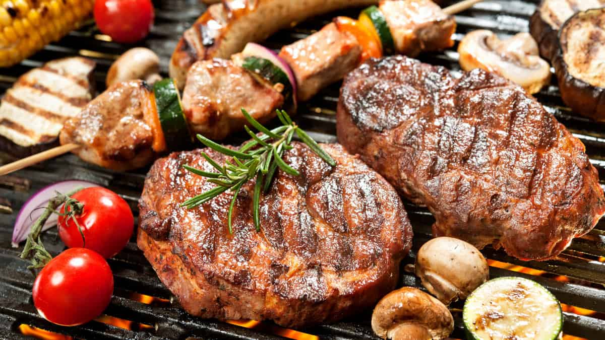 Close up of steak, kebabs and vegetables being grilled