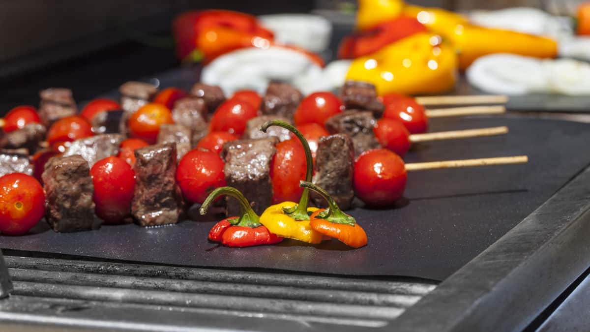 Skewered meat and veg on a grill mate on a BBQ