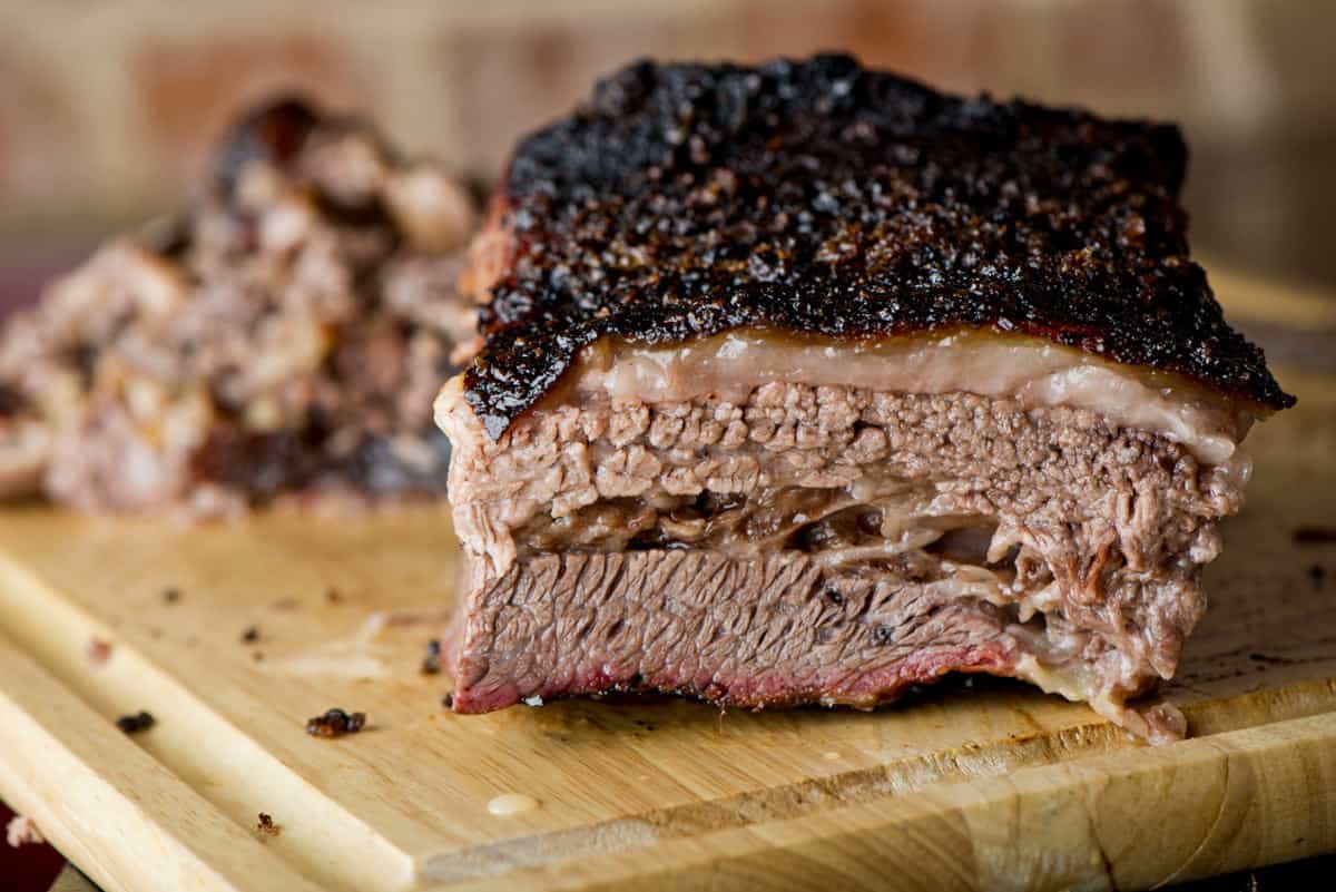 A large chunk of smoked beef brisket on a cutting board