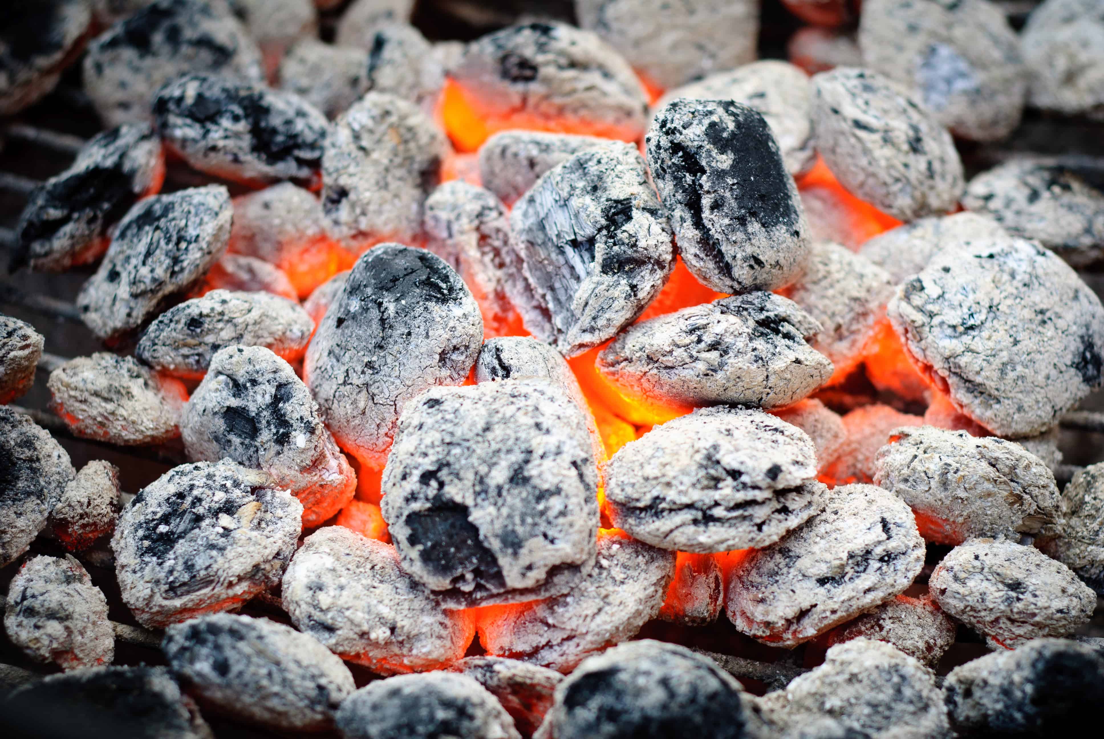 Close up of some red hot, ashed over burning briquettes