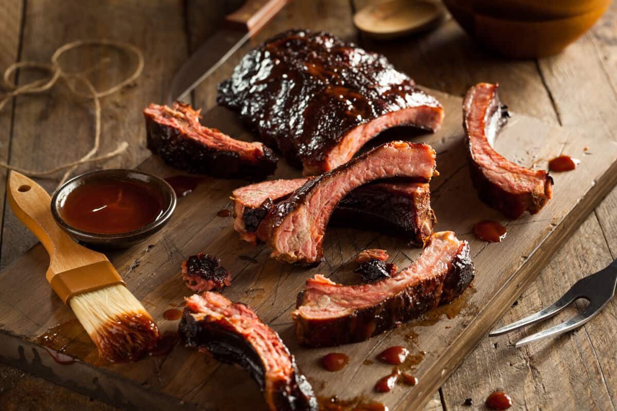 Sauced, sliced baby back ribs on a wooden surface