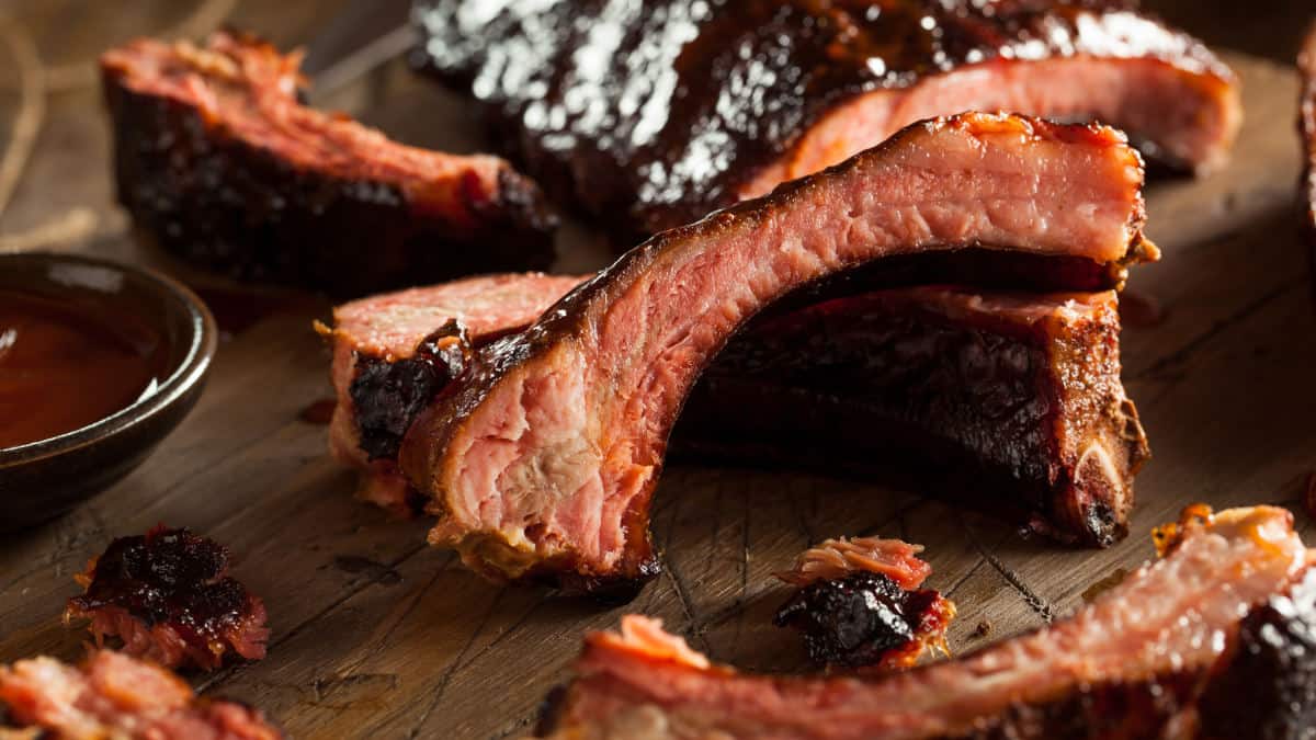 Close up of some sliced, bbq baby back ribs with a dark sticky sauce