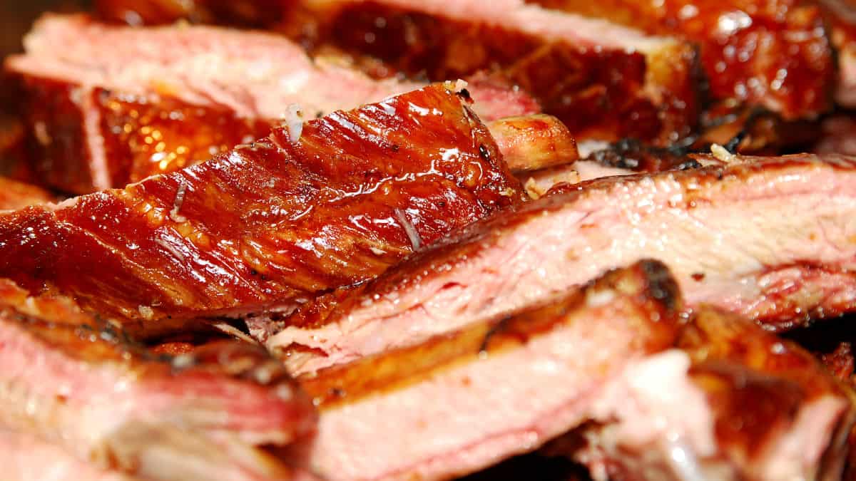 Close up of bbq pork ribs, slathered in a deep red sauce