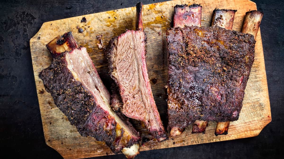 Overhead shot of some smoked and sliced beef ribs on a cutting board