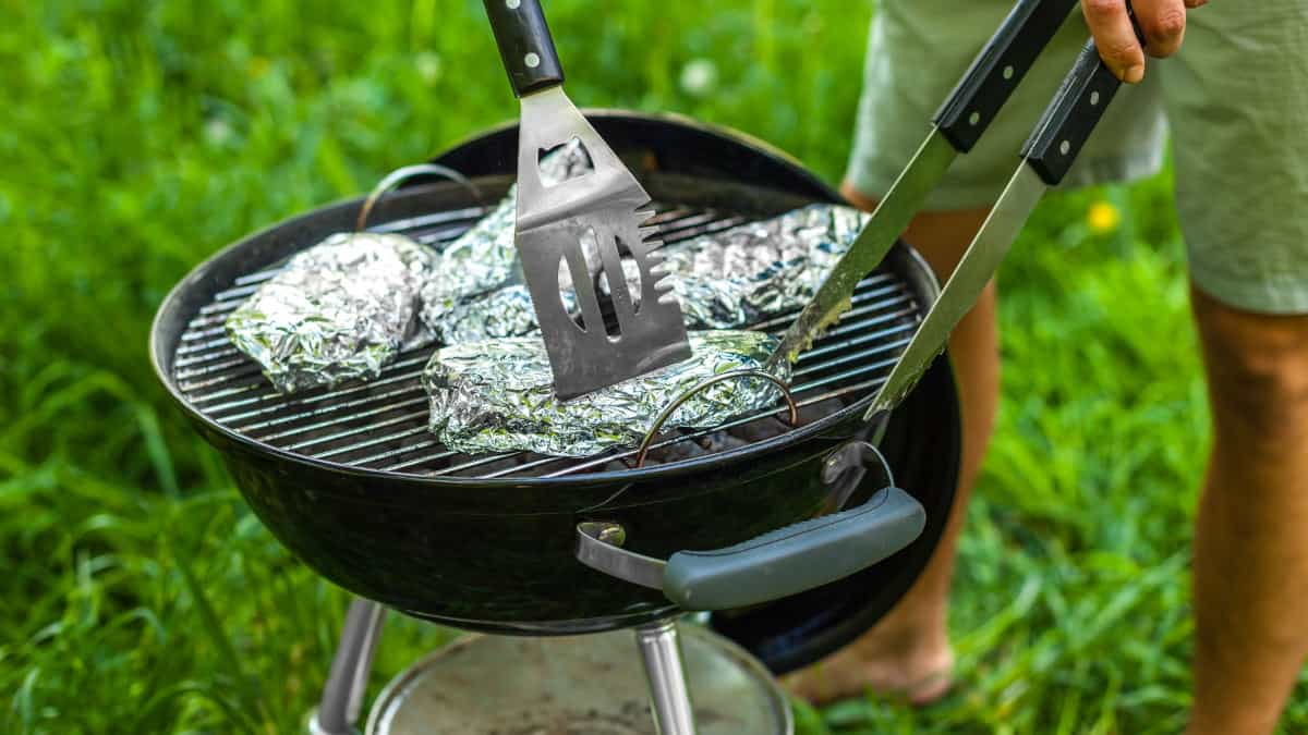 A few items wrapped in foil on a charcoal grill