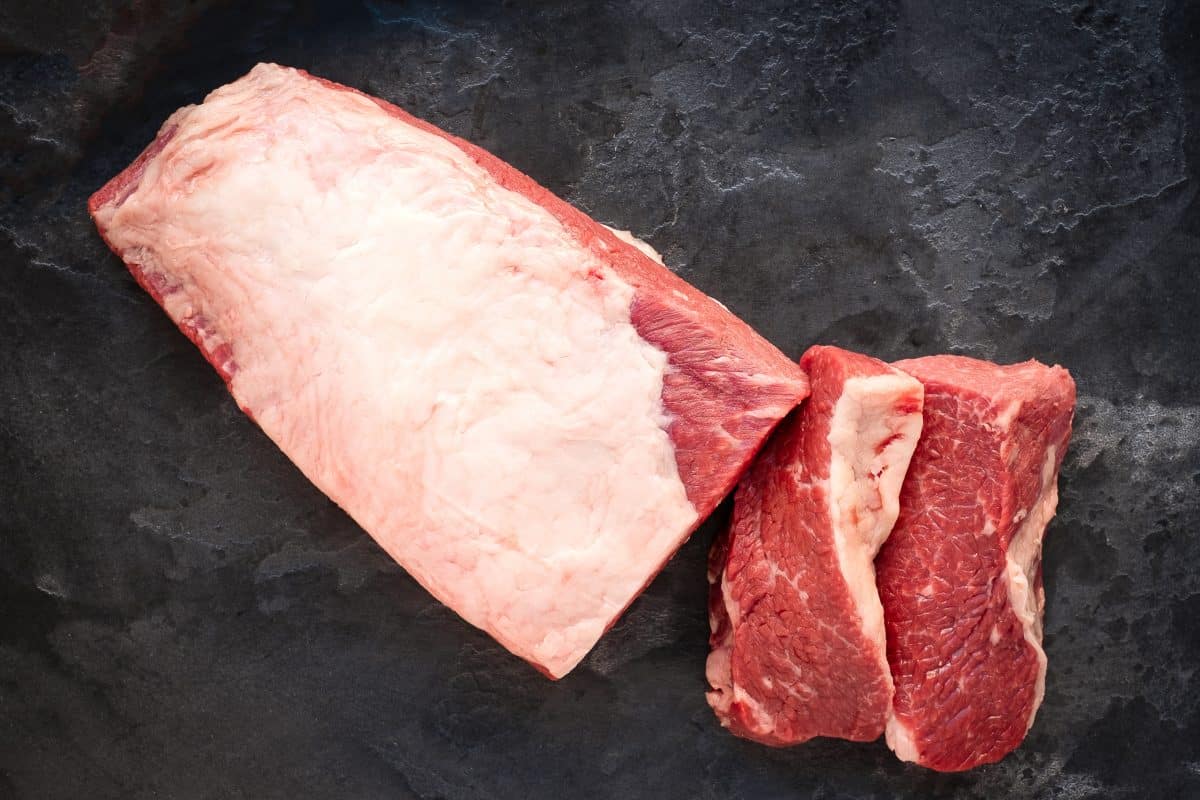 A top view of a brisket flat with fat cap, sliced in half